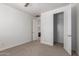 Bedroom with neutral carpet, a door to a bath and an open closet at 3818 E Quail Ave, Phoenix, AZ 85050