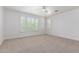 Bright bedroom with neutral carpet, ceiling fan, and large windows with plantation shutters at 3818 E Quail Ave, Phoenix, AZ 85050