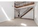 Open-concept living room featuring a staircase, second-floor balcony, and expansive tiled flooring at 3818 E Quail Ave, Phoenix, AZ 85050