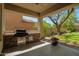 Outdoor kitchen and patio area with built-in grill, brick accents and green backyard at 3818 E Quail Ave, Phoenix, AZ 85050