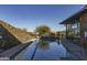 Lap pool with clear blue water, complemented by a stone wall and modern building structure at 3818 E Quail Ave, Phoenix, AZ 85050