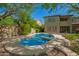 Backyard featuring a pool and hot tub, surrounded by lush desert landscaping at 3818 E Quail Ave, Phoenix, AZ 85050