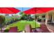 A serene backyard with a putting green, palm trees, and covered patio seating, perfect for relaxation at 4617 E Emile Zola Ave, Phoenix, AZ 85032