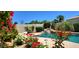 Scenic pool with a rock waterfall feature and colorful garden landscaping in a backyard oasis at 4617 E Emile Zola Ave, Phoenix, AZ 85032