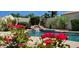 Beautiful pool with a rock waterfall feature and vibrant flowers in a serene backyard setting at 4617 E Emile Zola Ave, Phoenix, AZ 85032
