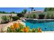 Lush pool area with a rock waterfall feature, surrounded by vibrant flowers and tropical plants at 4617 E Emile Zola Ave, Phoenix, AZ 85032