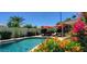 A stunning pool with lush landscaping, lounge chairs, and vibrant umbrellas creates a resort-like atmosphere at 4617 E Emile Zola Ave, Phoenix, AZ 85032