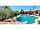 Inviting pool area with a rock waterfall feature, surrounded by lush landscaping and patio furniture at 4617 E Emile Zola Ave, Phoenix, AZ 85032