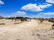 Spacious backyard with various buildings, benches, and mature vegetation at 50525 W Whirly Bird Rd, Maricopa, AZ 85139