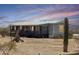 Single-story home featuring a covered porch and desert landscaping with beautiful desert sunsets at 50525 W Whirly Bird Rd, Maricopa, AZ 85139