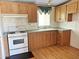 Functional kitchen with laminate floors, light wood cabinets, and white appliances at 50525 W Whirly Bird Rd, Maricopa, AZ 85139