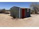 Exterior view of shed with painted red door and desert landscape at 50525 W Whirly Bird Rd, Maricopa, AZ 85139