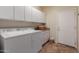 Well-lit laundry room with washer, dryer, storage cabinets, and tile flooring at 6418 S Pinaleno Pl, Chandler, AZ 85249