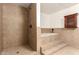 Bathroom featuring a shower with dark fixtures, a soaking tub, and tiled walls at 7340 W Meadowbrook Ave, Phoenix, AZ 85033