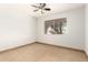 This bedroom has tile floors, a ceiling fan, and a window with natural light at 7340 W Meadowbrook Ave, Phoenix, AZ 85033