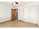 Bedroom with light tile flooring, wooden door and closet with sliding doors at 7340 W Meadowbrook Ave, Phoenix, AZ 85033