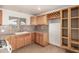 Kitchen featuring wood cabinets, tile backsplash, and built-in wine rack for entertaining at 7340 W Meadowbrook Ave, Phoenix, AZ 85033