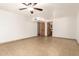 A spacious room with light colored tile flooring, a ceiling fan, and views into the hall and bath at 7340 W Meadowbrook Ave, Phoenix, AZ 85033