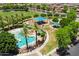 Aerial view of the community pool, playground, and park with mature trees in a well-maintained neighborhood at 7718 W Pipestone Pl, Phoenix, AZ 85035