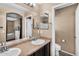 The bathroom features a double vanity, dark cabinets, and a separate toilet room at 7718 W Pipestone Pl, Phoenix, AZ 85035