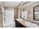 Bathroom with double sinks, dark cabinets, and a shower/tub combo with white tile at 7718 W Pipestone Pl, Phoenix, AZ 85035