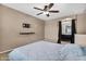 Bedroom features ceiling fan, TV mount, and opens to the bathroom via arched entrance at 7718 W Pipestone Pl, Phoenix, AZ 85035