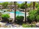 Community pool surrounded by palm trees, green landscaping, and neighborhood homes at 7718 W Pipestone Pl, Phoenix, AZ 85035