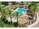 Aerial view of community pool area featuring lounge chairs, palm trees, and shaded seating at 7718 W Pipestone Pl, Phoenix, AZ 85035