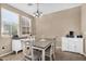 A well-lit dining room with a table and chairs, two white buffets and neutral decor at 7718 W Pipestone Pl, Phoenix, AZ 85035