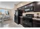 Well-appointed kitchen features dark cabinetry, black appliances, and a breakfast nook with great natural light at 7718 W Pipestone Pl, Phoenix, AZ 85035