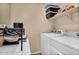 Functional laundry room with washer, dryer, shelving, and space for folding at 7718 W Pipestone Pl, Phoenix, AZ 85035