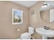 Cozy powder room featuring toilet, pedestal sink, and whimsical wall decor at 7718 W Pipestone Pl, Phoenix, AZ 85035