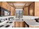 Well-lit kitchen features wood cabinetry, stainless sink, and black appliances at 7750 E Broadway Rd # 357, Mesa, AZ 85208