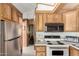 Open kitchen with stainless steel refrigerator, wood cabinets and white countertops at 7750 E Broadway Rd # 357, Mesa, AZ 85208