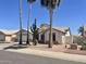 Charming single-story home with well-maintained landscaping, mature palm trees, and a desert-friendly yard at 8759 W Port Au Prince Ln, Peoria, AZ 85381
