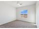 Bedroom with carpet flooring, ceiling fan, and window providing ample natural light and neighborhood views at 11227 E Crescent Ave, Mesa, AZ 85208