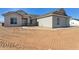 Single-story home featuring modern gray stucco, desert landscaping, and a sidewalk at 11227 E Crescent Ave, Mesa, AZ 85208