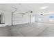 Spacious three car garage with concrete flooring and automatic doors and natural light at 11227 E Crescent Ave, Mesa, AZ 85208