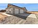 A three car garage at the end of a long driveway on a home in a rural setting at 11227 E Crescent Ave, Mesa, AZ 85208