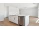 Bright kitchen island with white cabinets, stainless steel dishwasher, sink, and wood-look flooring at 11227 E Crescent Ave, Mesa, AZ 85208