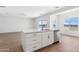 Bright kitchen island with white cabinets, stainless steel dishwasher, sink, and wood-look flooring at 11227 E Crescent Ave, Mesa, AZ 85208