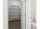 Bright walk-in closet features carpet flooring and white shelving for optimal storage in this modern home at 11227 E Crescent Ave, Mesa, AZ 85208