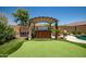 Backyard putting green with a covered hot tub providing the perfect place to relax outdoors at 11936 W Alvarado Rd, Avondale, AZ 85392