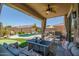Inviting covered patio area with outdoor seating overlooking a backyard featuring a pool and a putting green at 11936 W Alvarado Rd, Avondale, AZ 85392