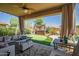Inviting covered patio with an outdoor seating area, a putting green, and a covered hot tub, perfect for relaxation at 11936 W Alvarado Rd, Avondale, AZ 85392