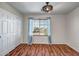 Cozy bedroom with wood floors, closet, blinds, a ceiling fan, and natural light from the window at 11936 W Alvarado Rd, Avondale, AZ 85392