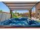 Inviting covered hot tub surrounded by a lush backyard with a waterfall pool and desert landscaping at 11936 W Alvarado Rd, Avondale, AZ 85392