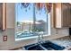 Kitchen sink view overlooking the pool with a waterfall feature and lush landscaping in the backyard at 11936 W Alvarado Rd, Avondale, AZ 85392