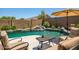 Inviting backyard pool features a rock waterfall, patio area, and mature landscaping at 11936 W Alvarado Rd, Avondale, AZ 85392