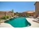 Sparkling pool with a rock waterfall feature and surrounding desert landscaping in a private backyard at 11936 W Alvarado Rd, Avondale, AZ 85392